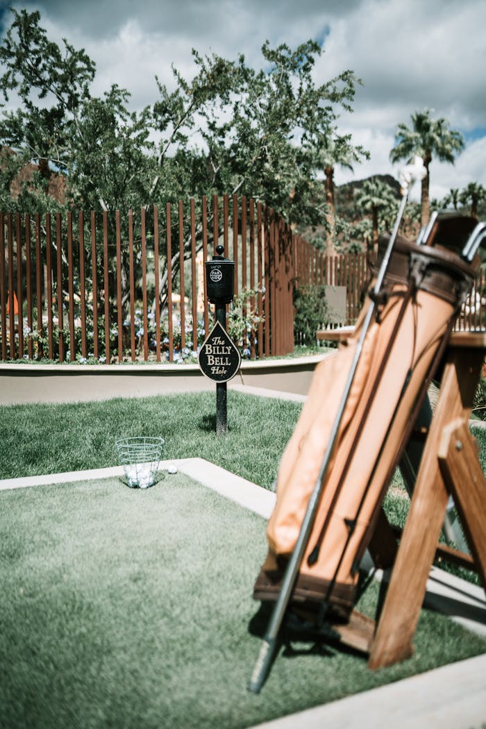 our-experience A scenic view of a golf course with a classic golf bag under a sunny sky.