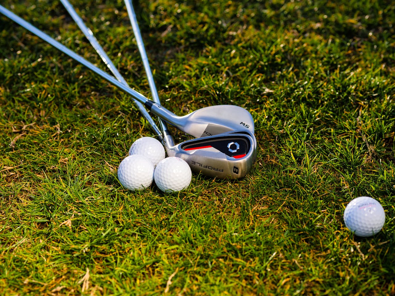 why-choose-us A close-up of golf clubs and balls on a lush, green golf course, perfect for outdoor sports enthusiasts.